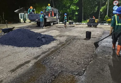 tim kontraktor jasa perbaikan jalan sedang melakukan pengaspalan