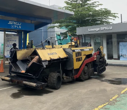 aspal curah diproses dalam pengaspalan jalan menggunakan asphalt paver dan alat berat