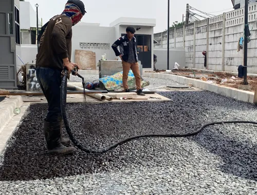 Aplikasi prime coat pada lapisan pondasi jalan sebelum pengaspalan