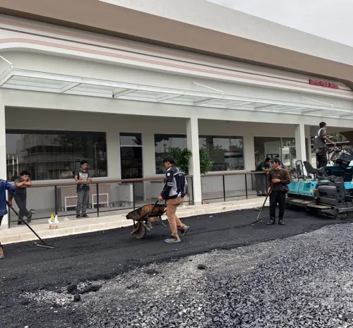 Pekerja menyemprotkan prime coat di proyek konstruksi jalan